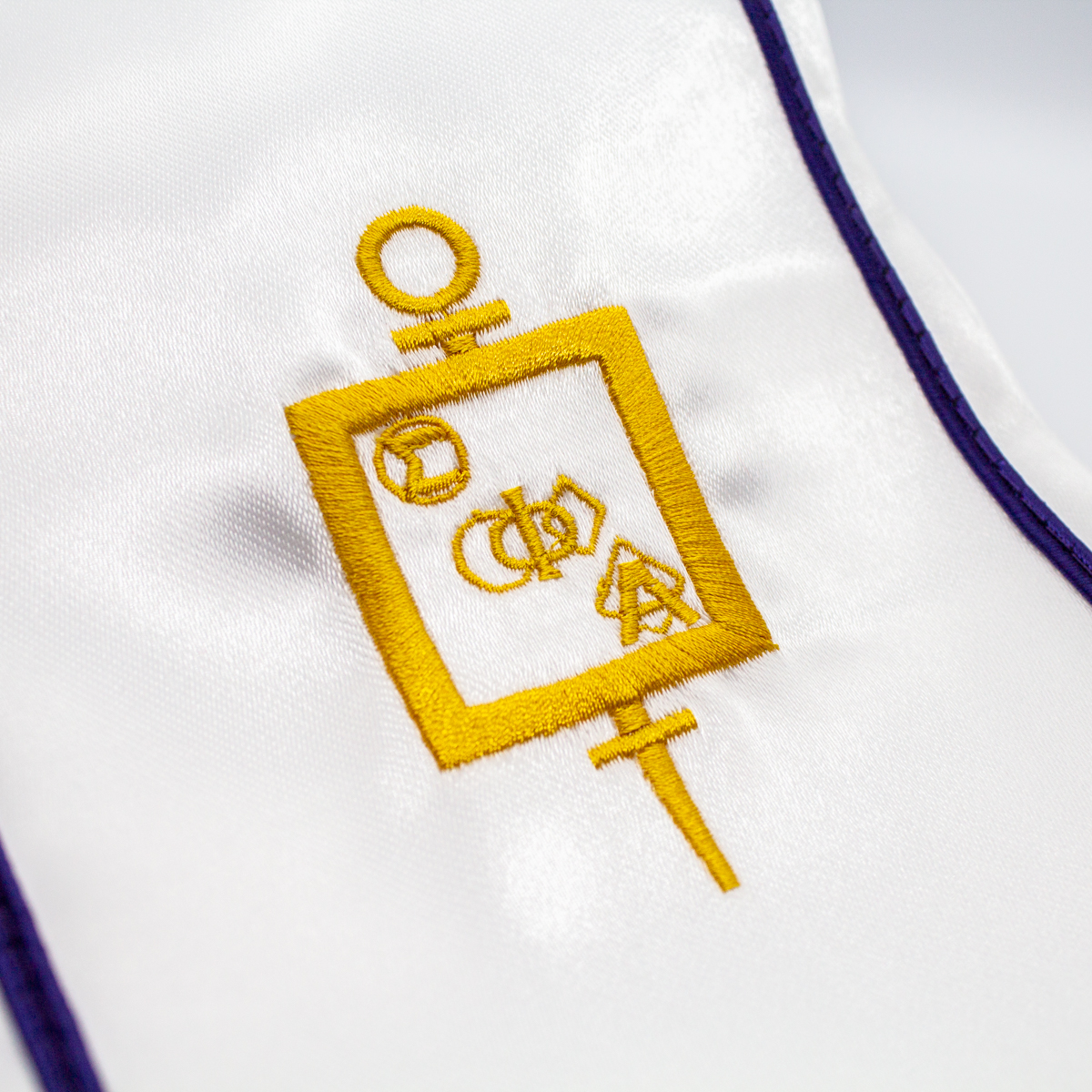 Closeup of Gold SPA Monogram Embroidery on White Satin Stole